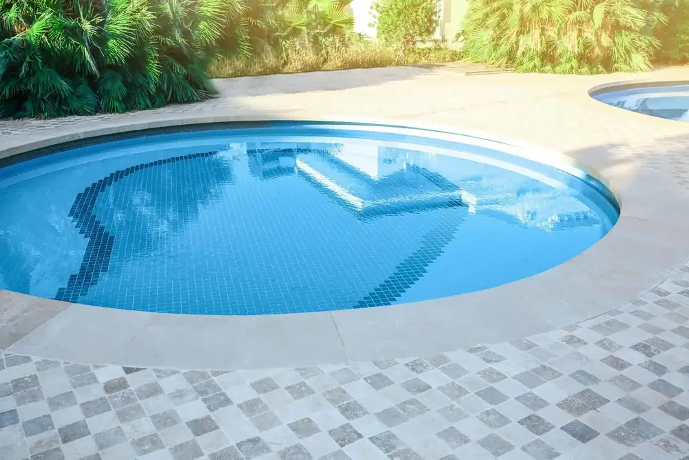 A finished residential pool with stone coping